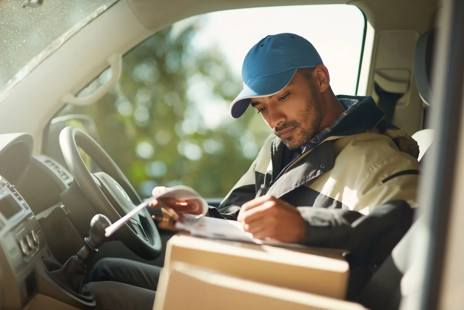 A driver reviews paperwork inside a commercial van.